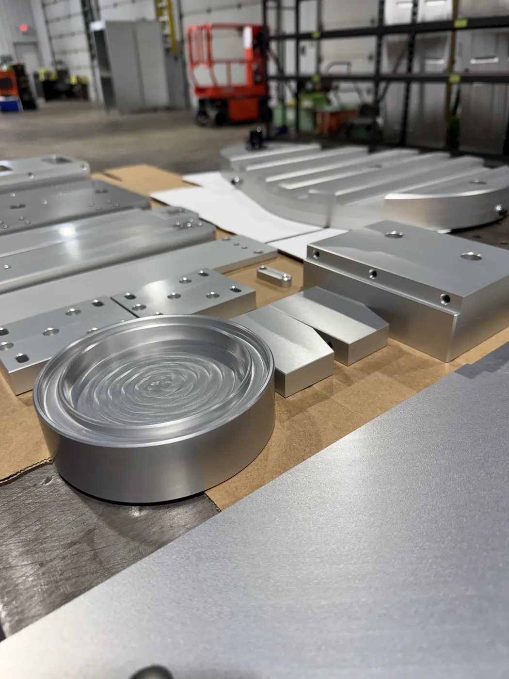 A group of finished aluminum parts laid out on a bench