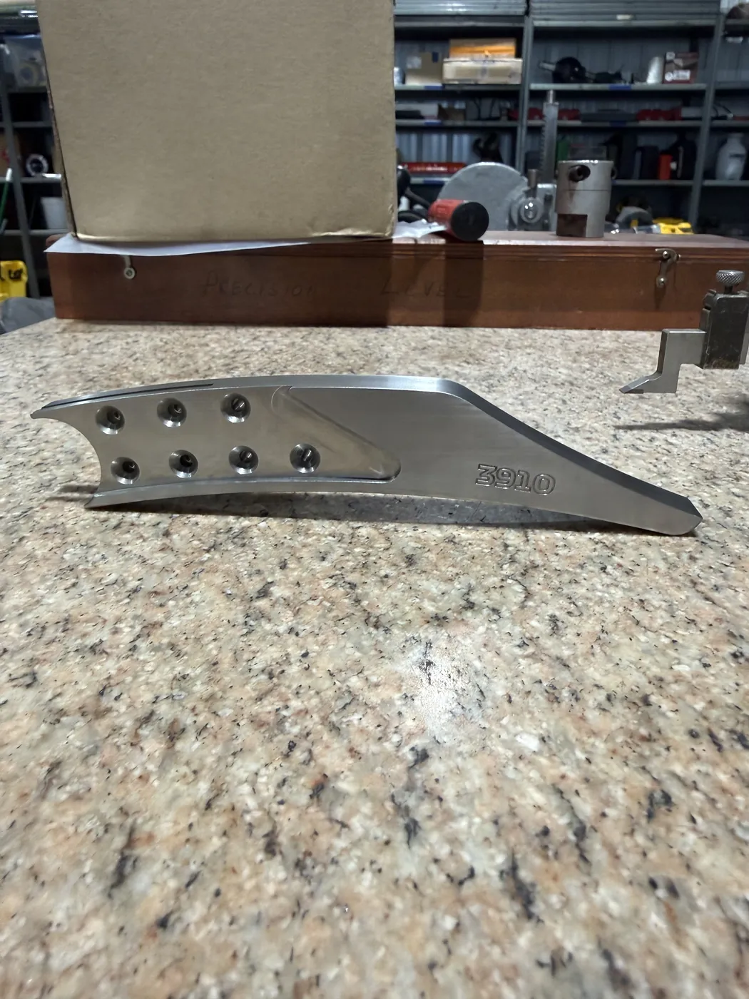 Contoured machined part with countersunk holes and an engraved part number