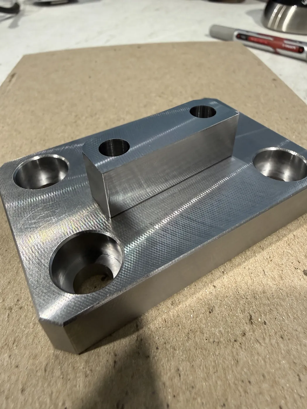 Machined steel block with counterbored holes and a raised key